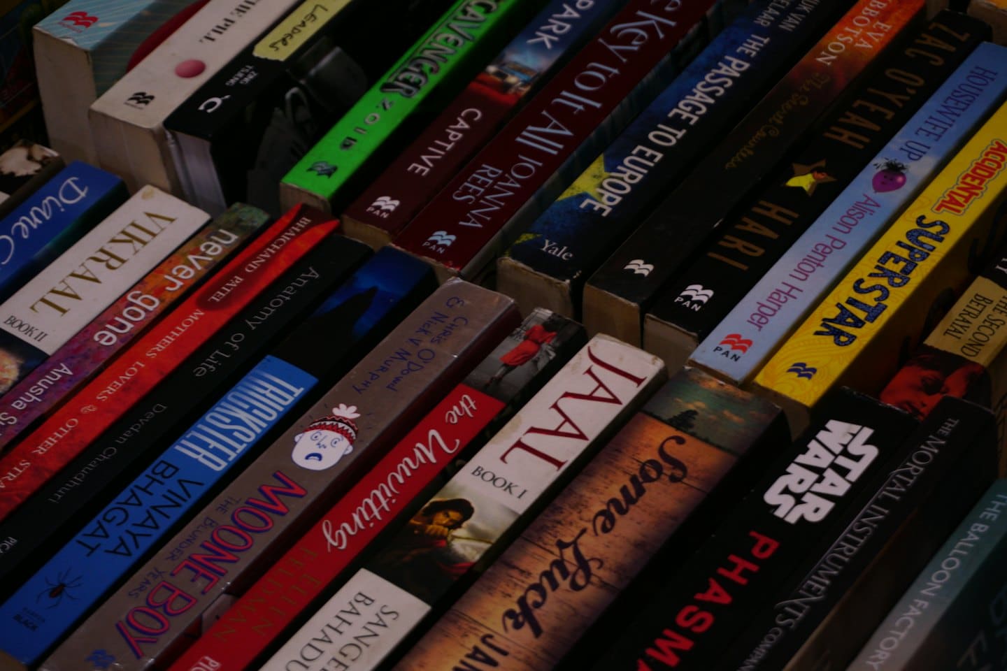 Many colorful book spines tightly packed together.