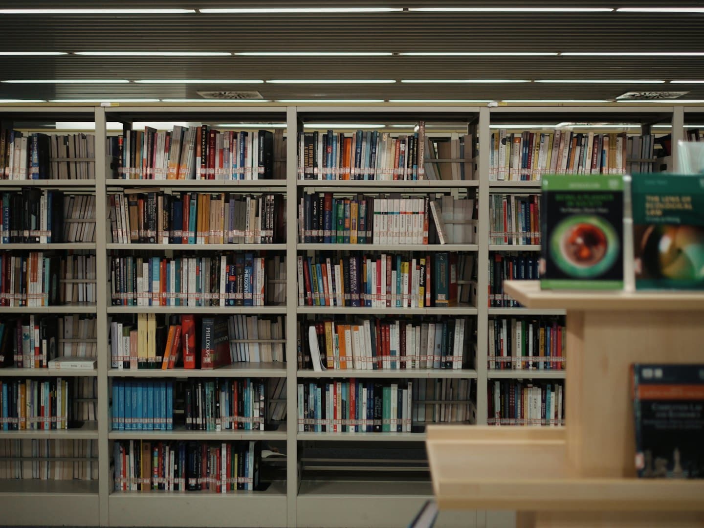 Metal bookshelves filled with books stand in a library.